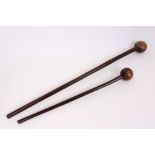 Two antique African carved hardwood knobkerries, each of typical form, with bulbous ball terminal,