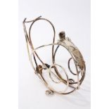 Victorian silver plated bottle holder of open scrolling wire construction, with paw foot,