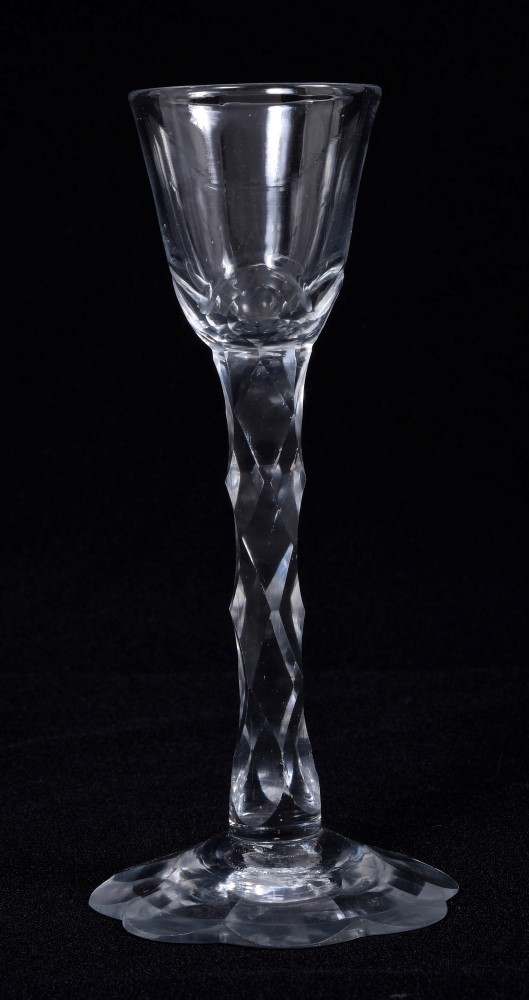 Georgian cordial glass with slice cut bell-shaped bowl and facet cut stem on cut petal-shaped foot,