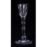 Georgian cordial glass with slice cut bell-shaped bowl and facet cut stem on cut petal-shaped foot,