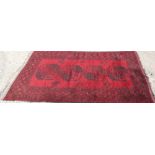 Pakistani Tekke-style rug with blood-red field and single row of four quartered medallions in