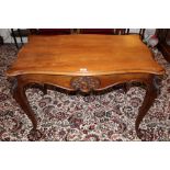 Late nineteenth century French walnut table with shaped top and asymmetric rococo carved frieze,