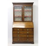 George III oak bureau bookcase with leaded glazed upper section,