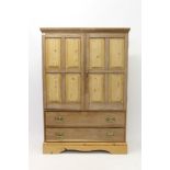 Antique pine cupboard with twin panelled doors and two drawers below on plinth base,