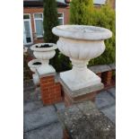 Set of six classical-style concrete garden urns of squat campana form on integral square base,