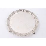 Edwardian silver pie crust salver on four claw and ball feet,
