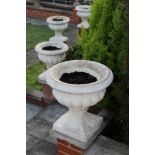 Set of six classical-style concrete garden urns of squat campana form on integral square base,