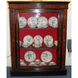 Late Victorian amboyna and ebonised pier cabinet enclosed by a glazed door, on plinth vase,