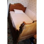 Late nineteenth century French walnut sleigh bed with carved scroll supports,