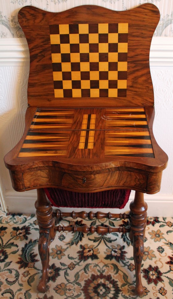 Victorian figured walnut games / sewing table of shaped outline,