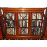 Modern yew wood and marble topped bookcase, enclosed by three doors on plinth vase, 133cm wide,