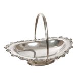 George V silver cake basket of oval form, with raised scroll border and swing handle,