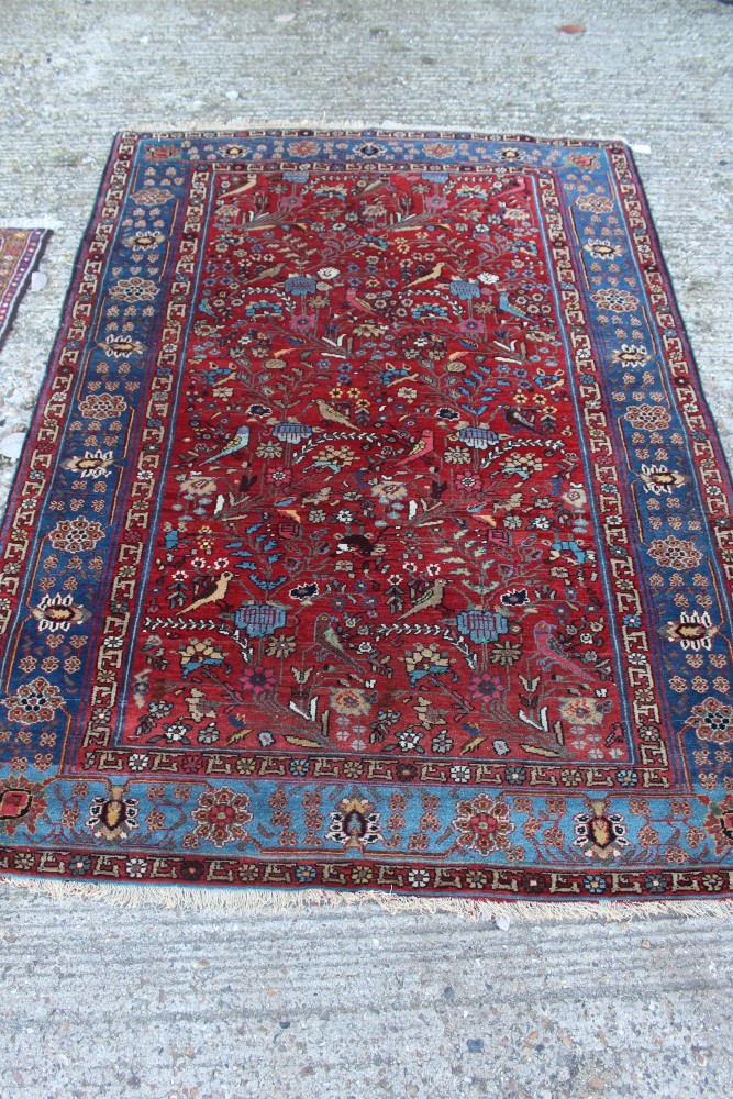 Kashan silk Tree of Life rug with blood-red field in blue meander main border, tassel ends,
