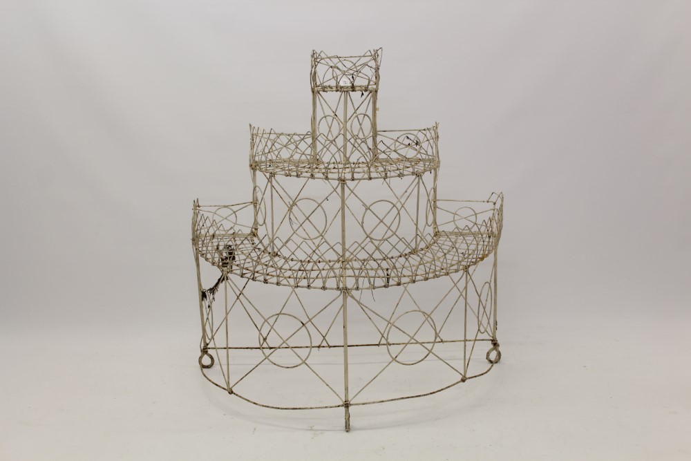 Antique three-tiered wirework plant stand of semi-circular outline with stepped tiers,