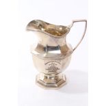 George V silver cream jug of faceted baluster form,