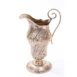 Victorian silver helmet cream jug with embossed scroll and floral decoration and scroll handle,