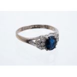 Sapphire and diamond ring with an oval mixed cut blue sapphire flanked by ten single cut diamonds