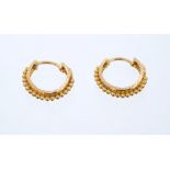 Pair Indian yellow metal hoop earrings with gold bead and red enamel decoration,
