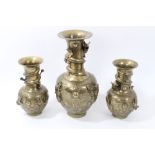 Garniture of three Chinese bronze vases, each of baluster form, with entwined dragons,