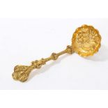 Unusual gilt metal sifter spoon with embossed fruit bowl and cast foliate stem with face mask and