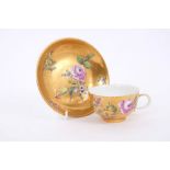 Mid-18th century Meissen gold ground tea cup and saucer with polychrome painted floral sprays -