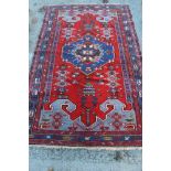 Persian tribal rug geometric medallion on coral red ground in geometric borders,