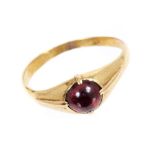 Antique cabochon garnet ring with a round garnet in four-claw heavy gold setting, on plain shank.
