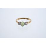 Early 20th century opal and diamond three-stone ring with a round opal cabochon flanked by two