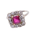 Ruby and diamond cluster ring with a rectangular step cut ruby measuring approximately 5.9 x 5.