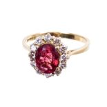 Tourmaline and diamond cluster ring with an oval mixed cut pink-red tourmaline measuring