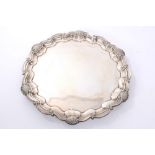 Early George V silver salver of hexagonal form, with piecrust border and scroll and shell rim,