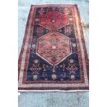 Eastern rug with aubergine ground and two conjoined medallions in multiple borders, 204cm x 113cm,