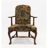 George I style walnut and tapestry upholstered armchair raised on cabriole legs united by an