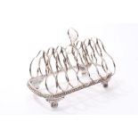 19th century white metal six-division toast rack of hooped form,