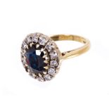 Sapphire and diamond cluster ring with an oval mixed cut blue sapphire measuring approximately 9.