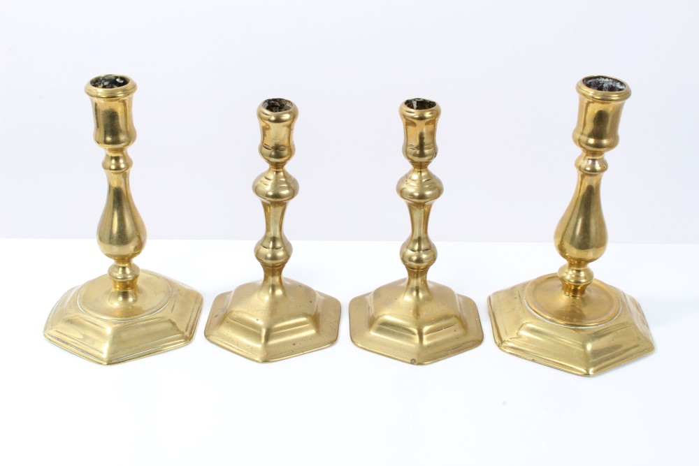 Two pairs of Queen Anne-style brass candlesticks, each with knopped baluster stem on hexagonal foot,
