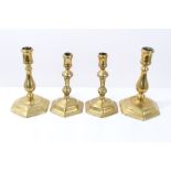 Two pairs of Queen Anne-style brass candlesticks, each with knopped baluster stem on hexagonal foot,