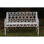 Gothic-style white painted metal garden bench with pierced tracery back and seat on square section