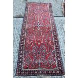 Kashan part silk narrow rug with geometric foliate branch work on blood red ground in flowered