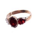 George III garnet three-stone ring with a central oval flat cut garnet flanked by two pear-shape
