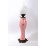 Late 19th century French brass and porcelain mounted oil lamp with pink body with gilt fleur-de-lys