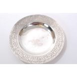 Chinese white metal dish of circular form, with dished centre and foliate engraved border,