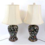 Pair of decorative Chinese famille noir table lamps, each of baluster form, decorated with foliage,
