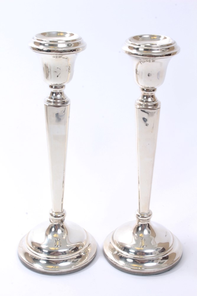 Pair contemporary silver candlesticks with octagonal tapering stems and inverted bell candle