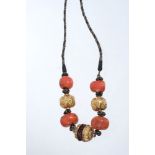 Fine antique Tibetan necklace with four large coral beads interspersed by three gold mounted beads