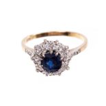 Sapphire and diamond cluster ring with a round mixed cut blue sapphire surrounded by ten brilliant