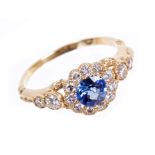 Sapphire and diamond flower cluster ring with a round mixed cut blue sapphire surrounded by a