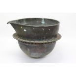 Unusual antique copper vessel of hemispherical form, with pinched spout and suspension band,