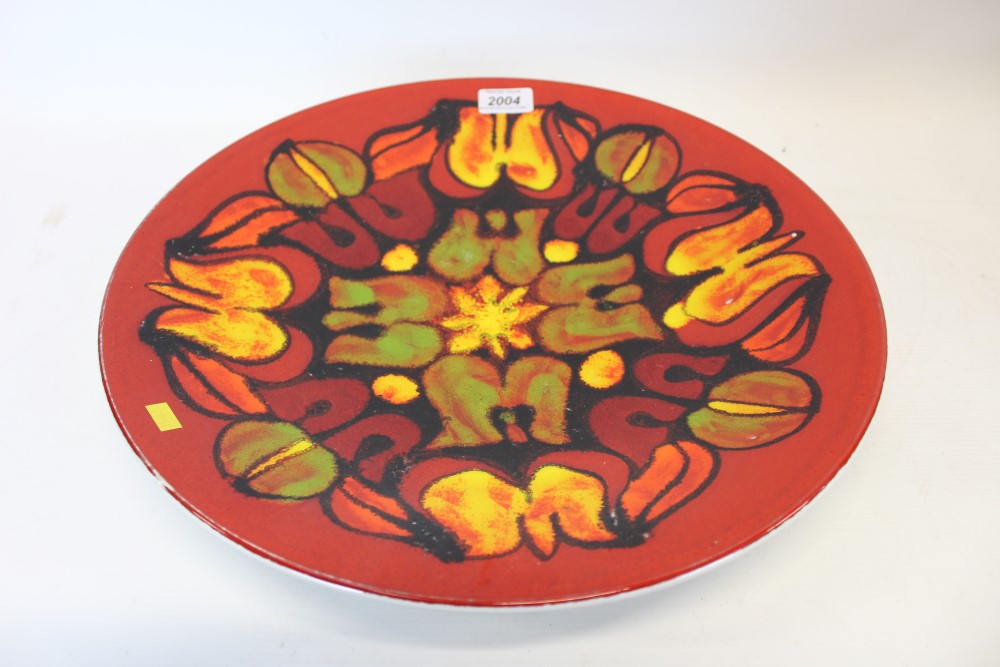 Poole Delphis circular charger with abstract floral decoration on red, orange,