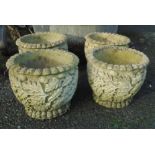 A set of four cast concrete planters with oak leaf decoration